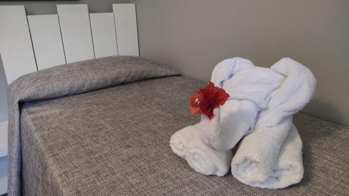 a white towel on a bed in a bedroom at Hotel - Résidence Habitation Grande Anse in Deshaies