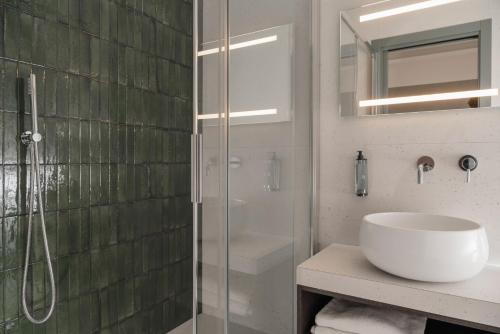 a bathroom with a sink and a glass shower at Hotel Sole in Riccione