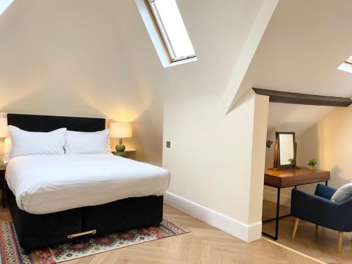 1 dormitorio con 1 cama y 1 silla azul en Glenlyn Hotel & Apartments, en Barnet