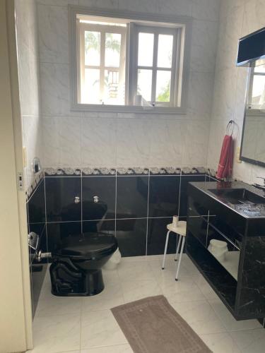 uma casa de banho com um WC preto e um lavatório. em Pousada Vivera em Jaraguá do Sul