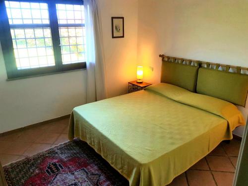 a bedroom with a bed and a window and a lamp at Villa Oliva in Canino