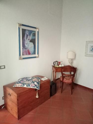 Cette chambre comprend un lit, une table et une photo. dans l'établissement casamachiavelli, à San Casciano in Val di Pesa