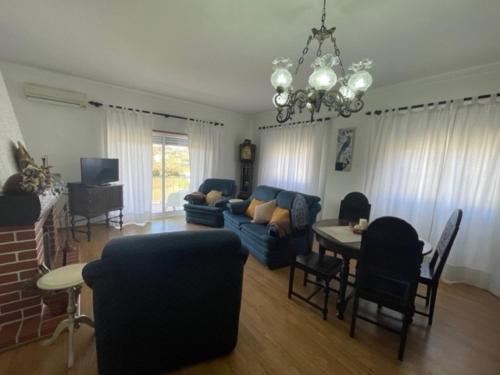 a living room with a blue couch and a table at Quinta do Carvalheiro in Sobral de Monte Agraço