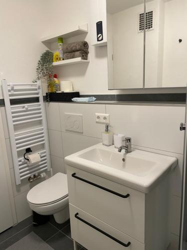 a bathroom with a white sink and a toilet at #4 modern & comfortable apartment in Memmingen