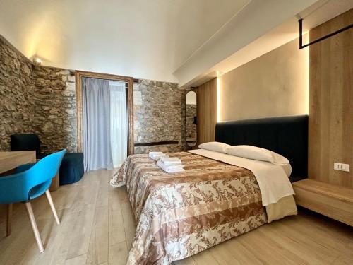 a bedroom with a bed and a table and a blue chair at Kefa Holiday - Balcone sul Mare in Cefalù