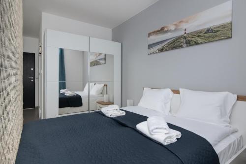 a bedroom with a large bed with towels on it at FALE BAŁTYKU in Gdańsk