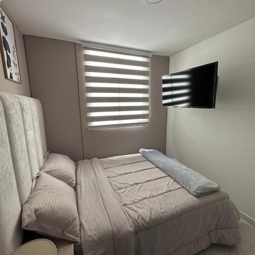 a bed in a room with a window and a bed sidx sidx sidx at Apartamento Amoblado Luxury Excelente Ubicacion in Cúcuta