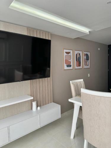 a living room with a large television and a table and chairs at Apartamento Amoblado Luxury Excelente Ubicacion in Cúcuta