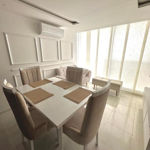 a dining room with a white table and chairs at Apartamento Amoblado Luxury Excelente Ubicacion in Cúcuta