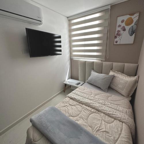 a bedroom with a bed and a flat screen tv at Apartamento Amoblado Luxury Excelente Ubicacion in Cúcuta