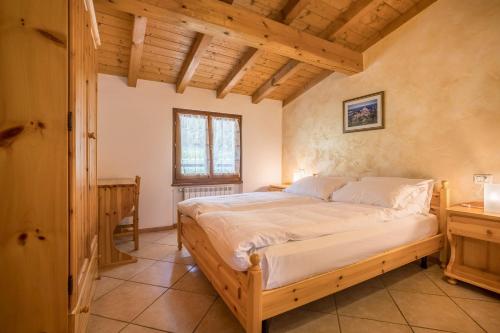 a bedroom with a bed and a wooden ceiling at Agriturismo Val d' Egoi 2 in Tremosine Sul Garda