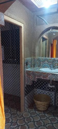 y baño con lavabo y espejo. en Auberge Amazigh, en Tamtetoucht