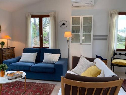 a living room with a blue couch and a table at Neuve Romantique in Montbrun-des-Corbières