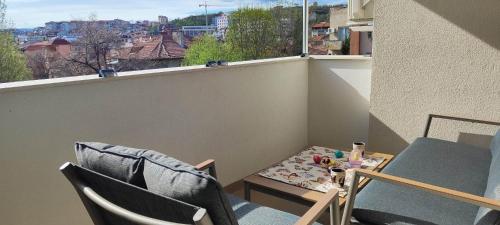 een klein balkon met 2 stoelen, een tafel en een raam bij Kiki Home in Blagoevgrad