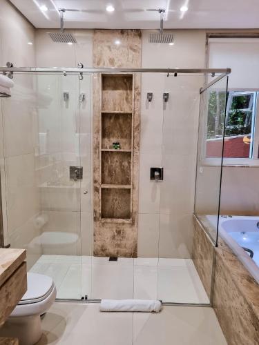 a bathroom with a glass shower and a toilet at Ananda Pousada in Pirenópolis