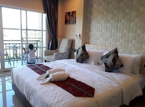 sypialnia z dużym białym łóżkiem z dzieckiem stojącym na nim w obiekcie 4 Palms Resort w mieście Bang Sare
