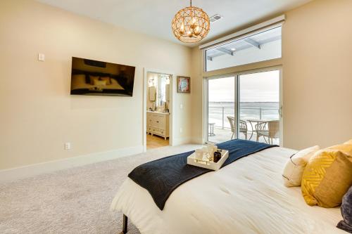 a bedroom with a bed with a view of the ocean at Waterfront Watertown Condo with Patio and Pool Access! in Watertown