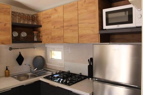 a kitchen with a stove and a microwave at Peponi Del Mar II in Biograd na Moru