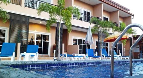 4 Palms Resort في بانغ ساري: مسبح وكراسي زرقاء ومظلة