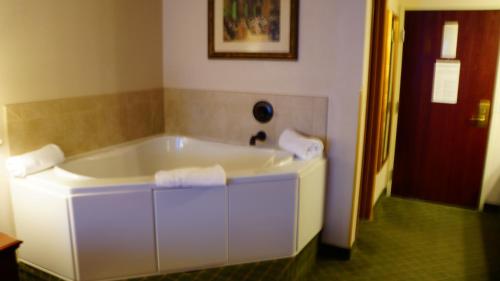 a white bath tub in a bathroom with a red door at Hotel Grand Victorian in Branson