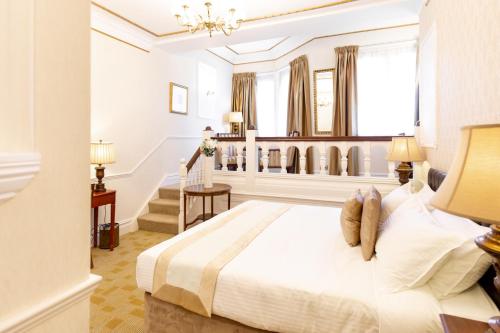 a bedroom with a large white bed and stairs at Botleigh Grange Hotel & Spa in Southampton