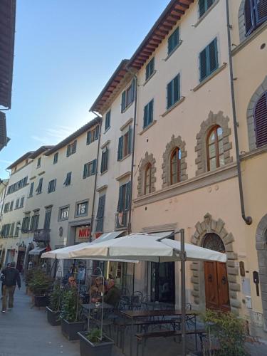 un bâtiment avec des tables et des parasols devant lui dans l'établissement casamachiavelli, à San Casciano in Val di Pesa