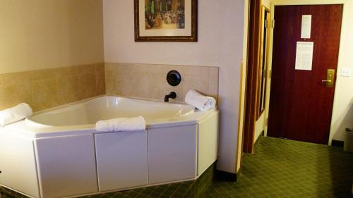 a white bath tub in a bathroom with a red door at Hotel Grand Victorian in Branson