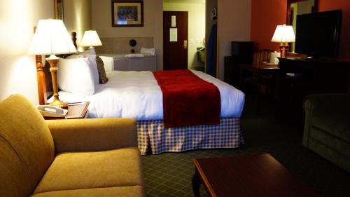 a hotel room with a bed and a couch at Hotel Grand Victorian in Branson