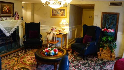 a living room with chairs and a table and a fireplace at Hotel Grand Victorian in Branson