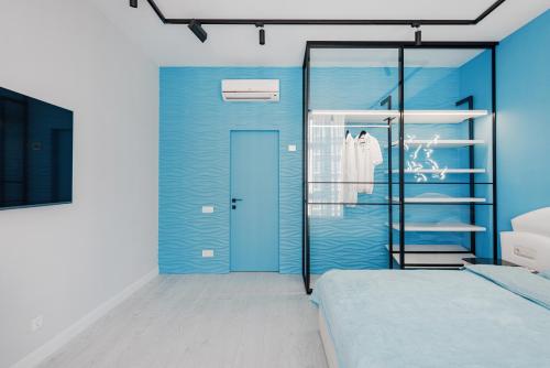 um quarto azul com uma cama e uma porta de vidro em THE BEST APARTMENT ON THE SEASIDE IN ODESA! Luxury apartments in Arcadia, near seaside! em Odessa