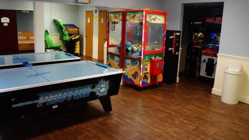 a room with a pool table and two arcade games at Hotel Grand Victorian in Branson