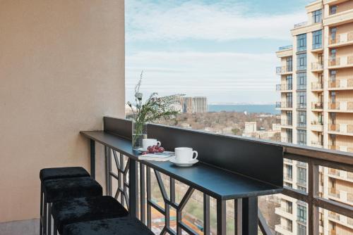 a balcony with a table and a view of the city at THE BEST APARTMENT ON THE SEASIDE IN ODESA! Luxury apartments in Arcadia, near seaside! in Odesa