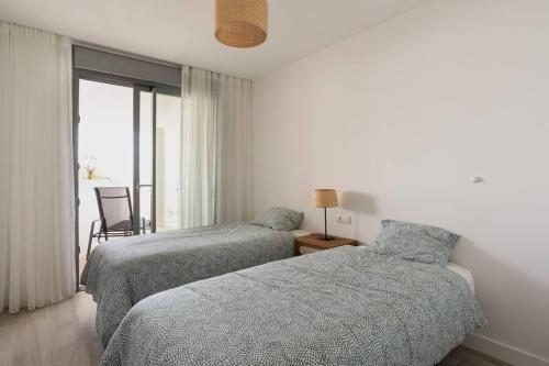 2 Betten in einem Hotelzimmer mit Fenster in der Unterkunft Mediterranean apartment with sea views in Mijas in Mijas