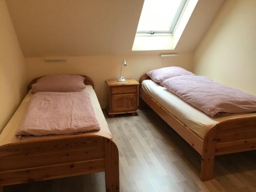 two twin beds in a room with a window at Haus Strandgang, Whg 5 in Kellenhusen