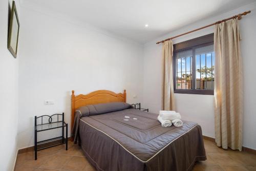 a bedroom with a bed and a window at Novobarrosa B in Chiclana de la Frontera