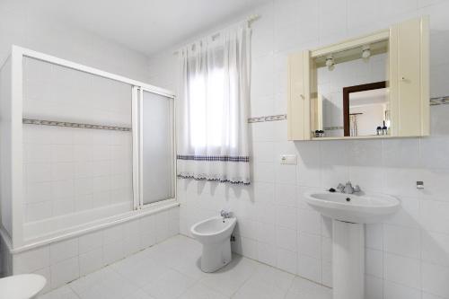 a white bathroom with a sink and a toilet at Novobarrosa B in Chiclana de la Frontera