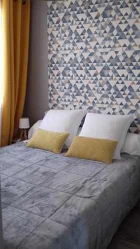 une chambre avec un grand lit avec des oreillers jaunes dans l'établissement Petite RAFALE, à Valras-Plage
