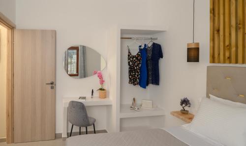 sypialnia z łóżkiem, lustrem i krzesłem w obiekcie Auster House Santorini w mieście Kamari
