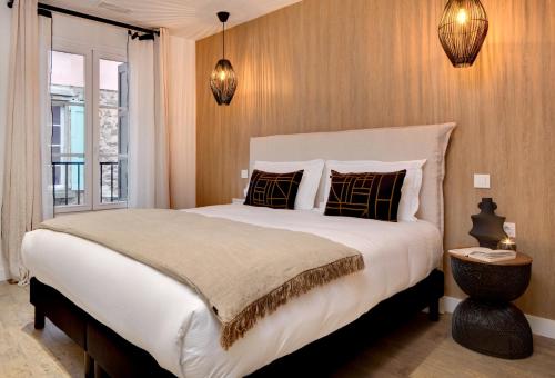 um quarto com uma grande cama branca e uma janela em Les Appartements de Collioure em Collioure