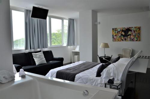 um quarto de hotel com uma cama e um sofá em Hotel iDesign em San Marino