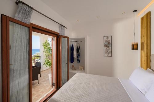 a bedroom with a bed and a balcony at Auster House Santorini in Kamari