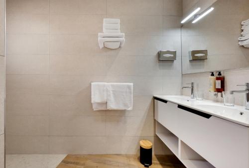 a white bathroom with a sink and a mirror at Les Appartements de Collioure in Collioure