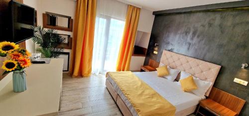 a bedroom with a bed and a vase of flowers at Summer Love in Mangalia