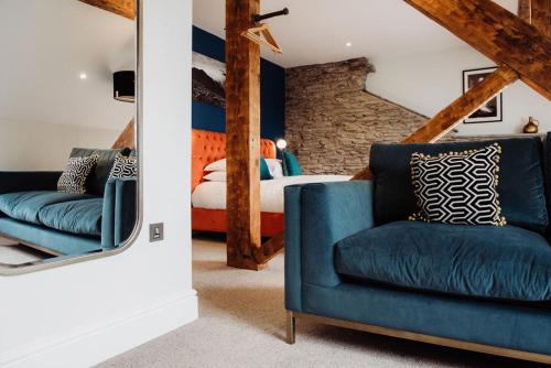 Un dormitorio con una silla azul y una cama en The Hafod, en Devils Bridge