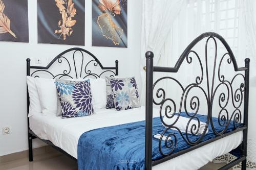 a black and white bed with blue sheets and pillows at L'IMMEUBLE QUEEN M.N.M in Douala