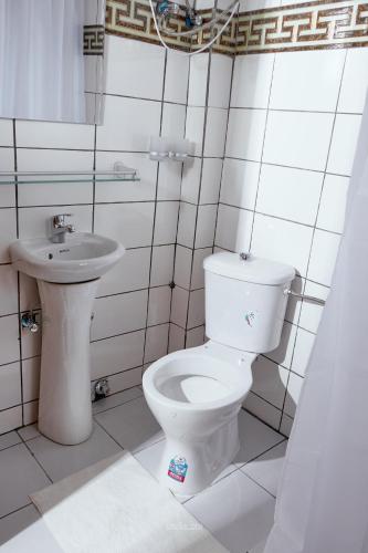 a bathroom with a toilet and a sink at L'IMMEUBLE QUEEN M.N.M in Douala
