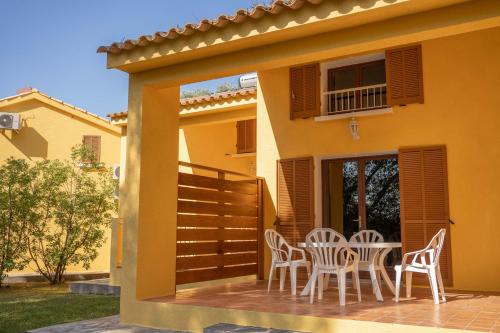 a patio with chairs and a table in front of a house at Residence Mare e Sole in Taglio-Isolaccio