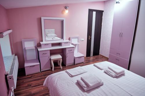 a bedroom with a white bed with a vanity and a mirror at RO METRO in Gyumri