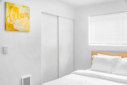 a white bedroom with a bed and a painting on the wall at Seattle Cloud 2BR Prime Location in Seattle