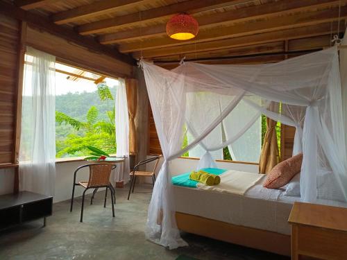 a bedroom with a canopy bed and a window at Frana Lodge in El Zaino